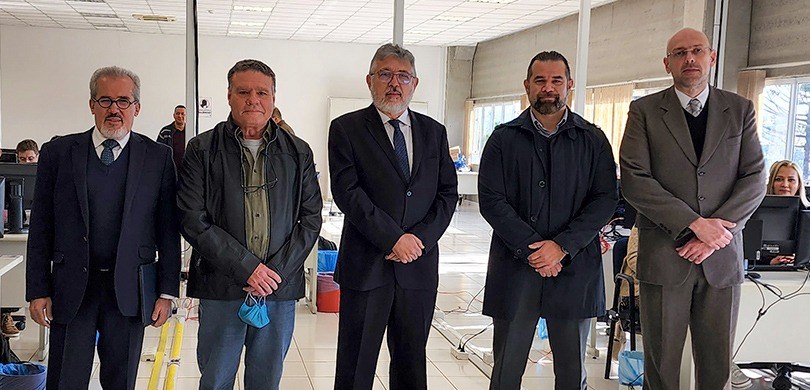 Fotografia de cinco homens posando para a foto em pé.