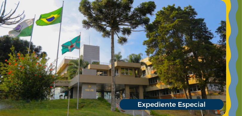 Fotografia que retrata a fachada de um edifício institucional de cor bege, com janelas de vidro ...