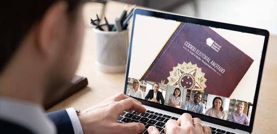 Imagem de um homem mexendo em um notebook, no qual a tela mostra uma imagem do Código Eleitoral ...