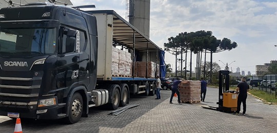 Foto da chegada de caminhões com materiais enviados pelo TSE