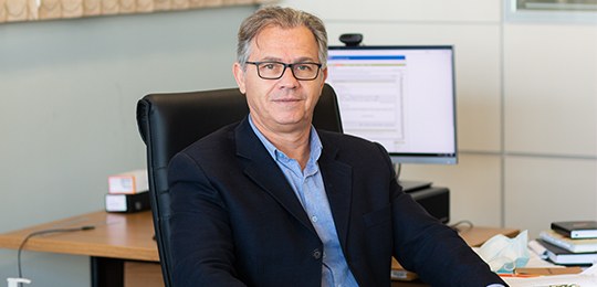 Foto do secretário da SECOFC do TRE-PR, Helton José Sanchez, sentado em uma cadeira preta