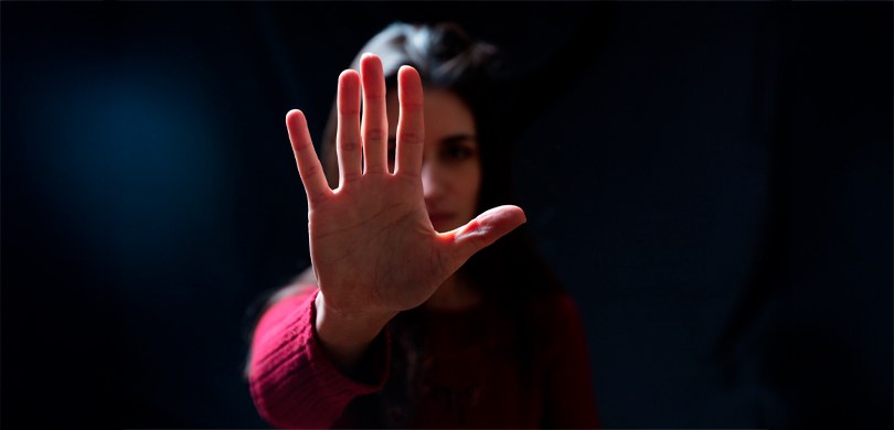 Na fotografia, há uma mulher de cabelos pretos e blusa de manga longa na cor vermelha. Ela está ...