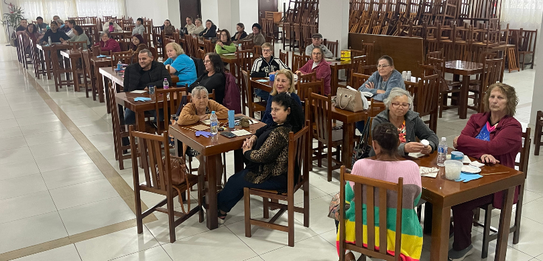 Fotografia de cinco pessoas, quatro homens e uma mulher, em uma sala clara. Dois rapazes com col...