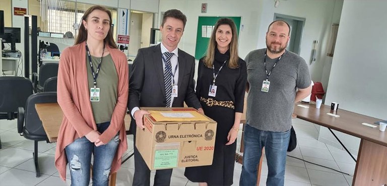Fotografia de quatro pessoas, sendo dois homens e duas mulheres. Um homem, que está ao centro, v...