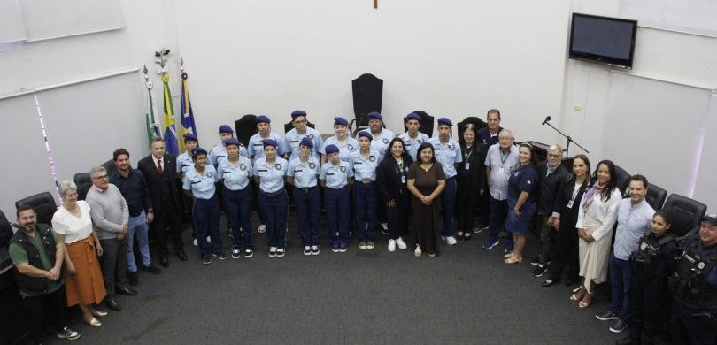 Fotografia na qual é possível ver estudantes e autoridades posando sorrindo, no plenário da Câma...