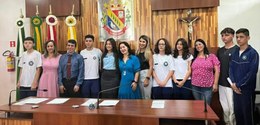 Fotografia de diversas pessoas, entre estudantes e pessoas adultas, posando sorrindo para foto. ...