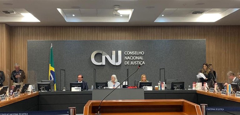 Vice-presidente do TRE-PR participa do 6° Fórum Nacional das Corregedorias Fotografia do plenário do Conselho Nacional de Justiça. Ao fundo, uma parede cinza com a logo do...