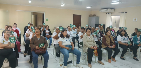 Fotografia de cinco pessoas, quatro homens e uma mulher, em uma sala clara. Dois rapazes com col...