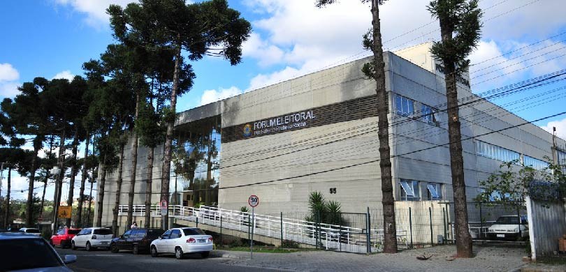 Fotografia da fachada de um prédio em frente do qual há uma rampa de acesso para pessoas com mob...