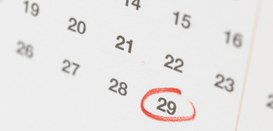 Fotografia de parte de um calendário branco, com números pretos. O dia 29 está circulado em verm...