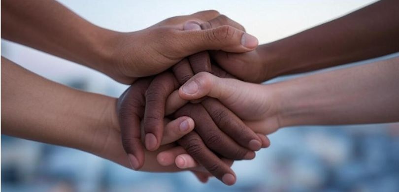 A discriminação racial também pode ser considerada assédio moral Fotografia de mãos entrelaçadas