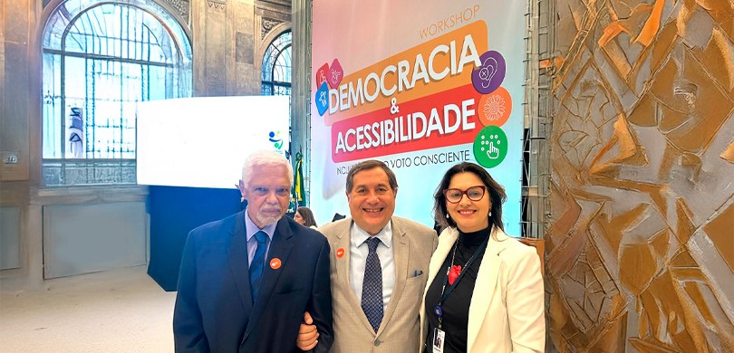 Assessora do TRE-PR participa de workshop sobre democracia e acessibilidade fotografia na qual dois homens e uma mulher estão posando sorrindo. Da esquerda para a direita, ...