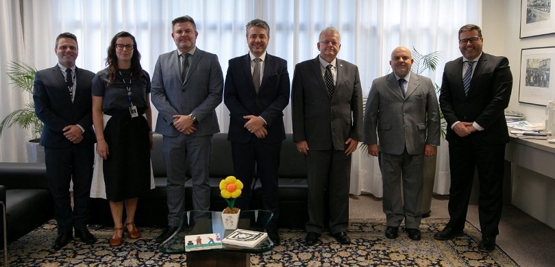 Foto em que aparecem de pé, no Gabinete da Presidência do TRE-PR, o presidente Sigurd, os desemb...