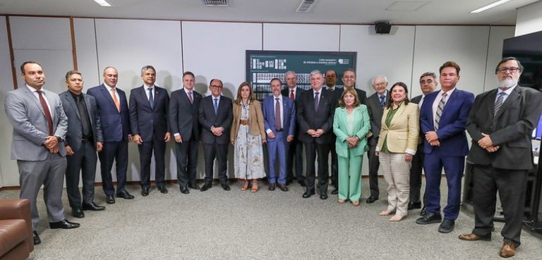 Fotografia de homens de terno e mulheres, que vestem roupas formais nas cores bege, verde e bran...