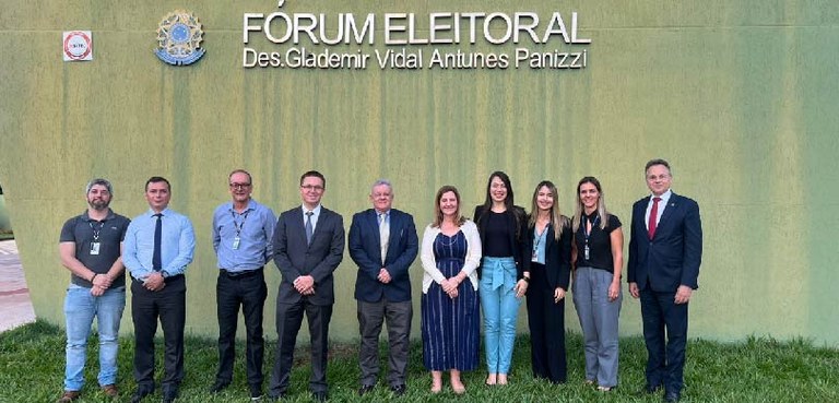 Seis homens e quatro homens estão perfilados em frente a uma parede verde do Fórum Eleitoral de ...