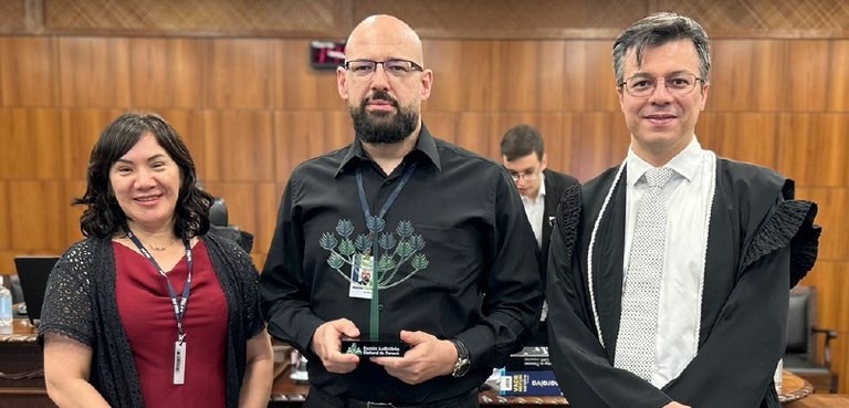 Fotografia de uma mulher, vestindo uma camiseta vermelha, um casaco preto de mangas curtas e o c...