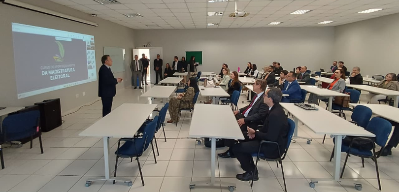 Juízes eleitorais participam do início de curso de aperfeiçoamento nesta sexta-feira (5) Fotografia em que aparecem, de lado, várias pessoas sentadas em direção ao vice-presidente do TR...