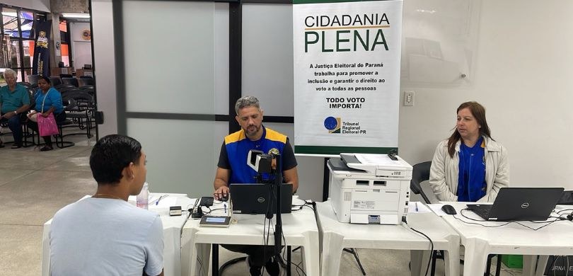 Justiça Eleitoral atende no Sesc Paranaguá até este sábado (26) Fotografia em que são vistos um homem e uma mulher, ambos identificados com o colete da Justiça ...