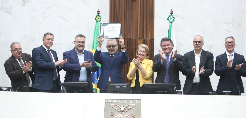 Foto em que aparecem oito pessoas na mesa de honra da Assembleia Legislativa do Paraná, entre el...