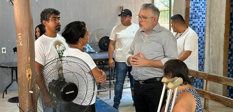 Foto do espaço interno onde se prestou atendimento aos eleitores. Em destaque, um homem de óculo...
