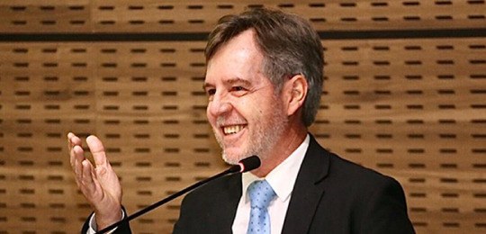 Nota de pesar pelo falecimento de Michel Micheleto, presidente da Associação das Emissoras de Radiofusão do Paraná Foto de uma pessoa de terno e gravata falando ao microfone