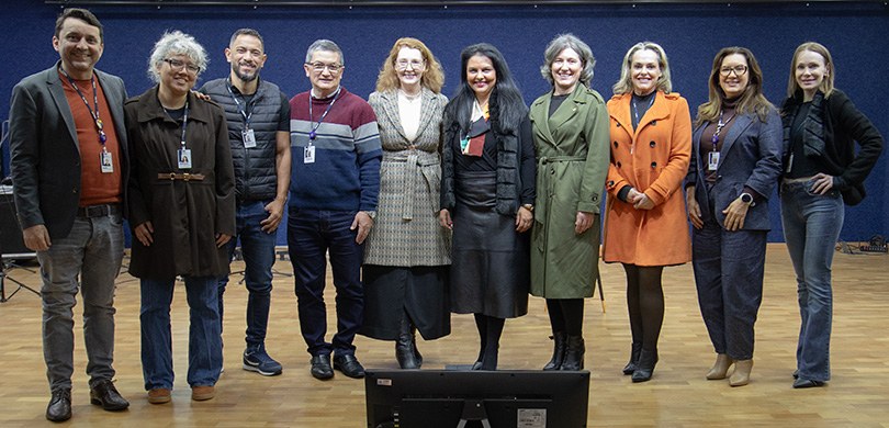 Fotografia em que se observa um grupo de dez pessoas, sendo quatro homens e seis mulheres, posan...
