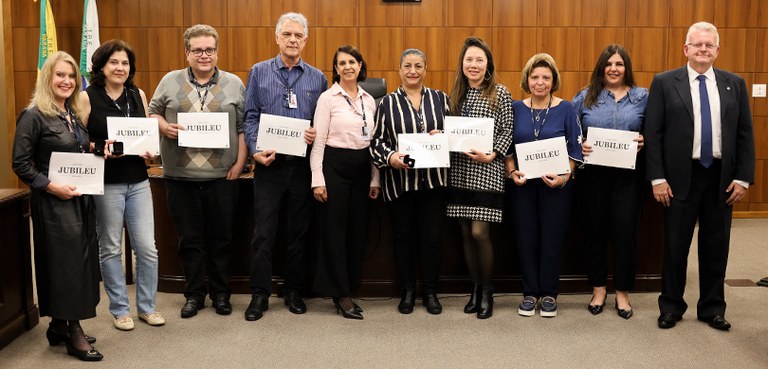 Vários homens e mulheres posam  sorrindo para a foto ao lado do presidente Sigurd. Eles seguram ...