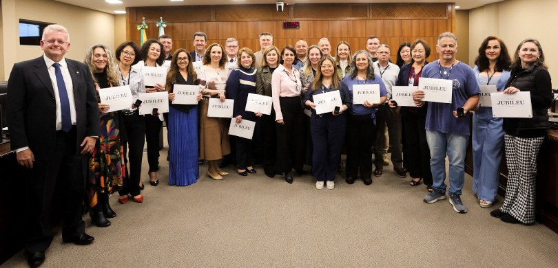 Vários homens e mulheres posam  sorrindo para a foto ao lado do presidente Sigurd. Eles seguram ...